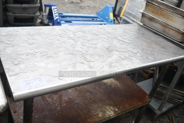 Commercial stainless steel table with under shelf, shows watermarks. sturdy legs, ideal for kitchen use. Some rust on under shelf.