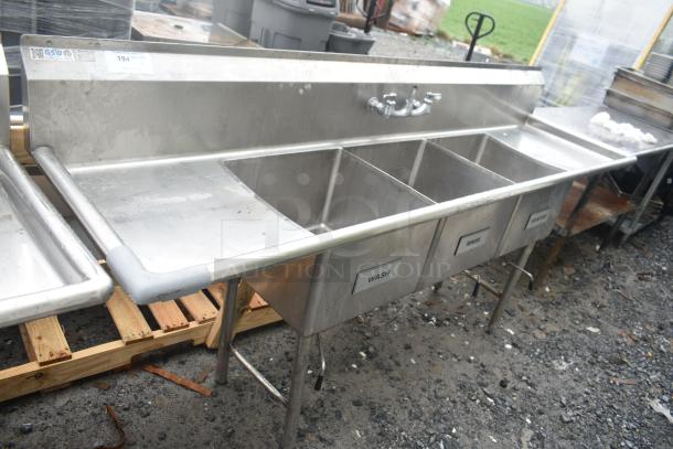 Commercial 3 bay sink with dual drain boards. Features labeled sections for wash, rinse, sanitize. Stainless steel, used condition.