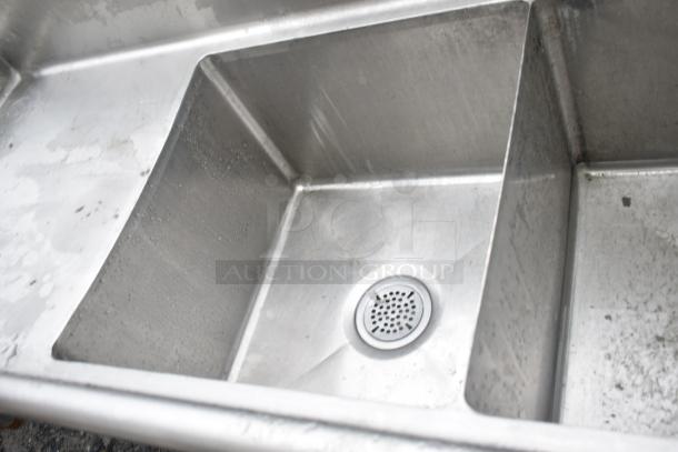 Commercial 3 bay sink with dual drain boards, stainless steel, used condition, visible wear, suitable for high-capacity use.