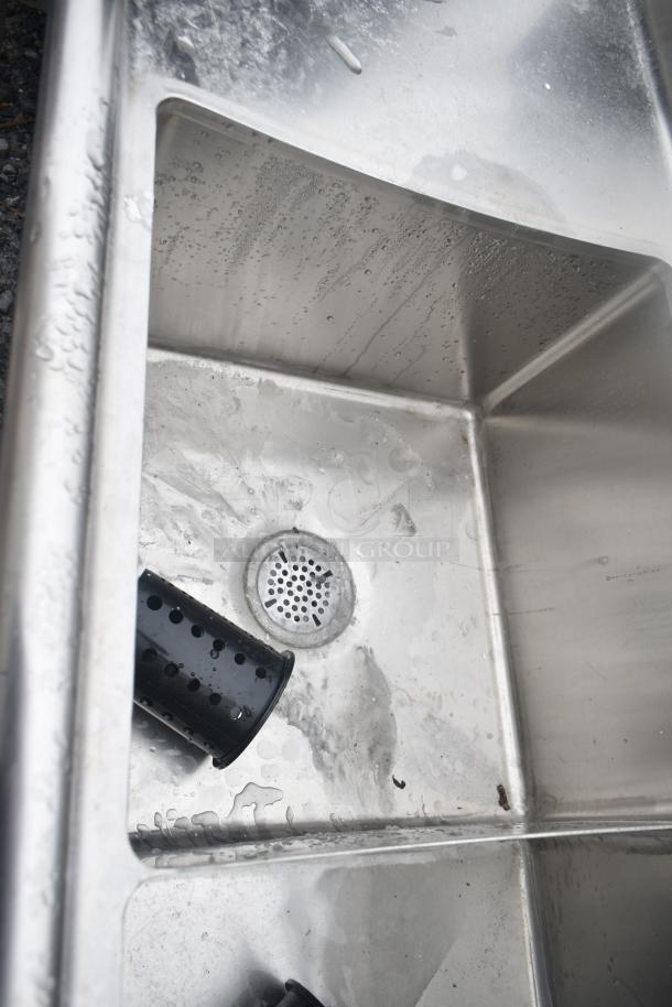 Commercial 3 bay sink with dual drain boards, stainless steel, lightly worn with minor water stains, includes black strainer.