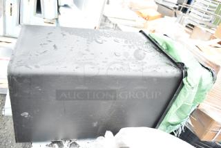 Two black poly trash cans, wet from rain, auction item offers bid multiplier—two cans for one bid price.