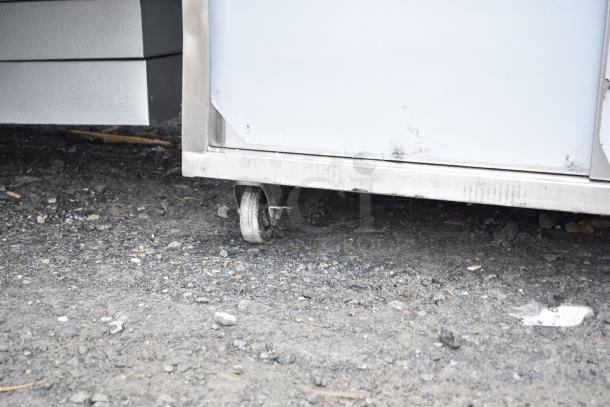 Regency stainless steel table with enclosed base, 30"x60". Features open front, adjustable midshelf. Used condition, visible caster.