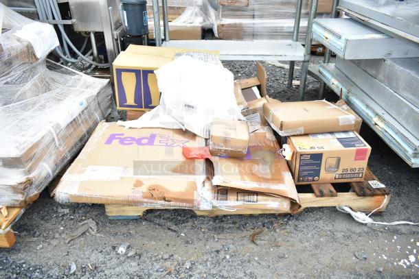 Brand new scratch and dent items on a pallet, including a Tork 256023 dispenser box, in original packaging.