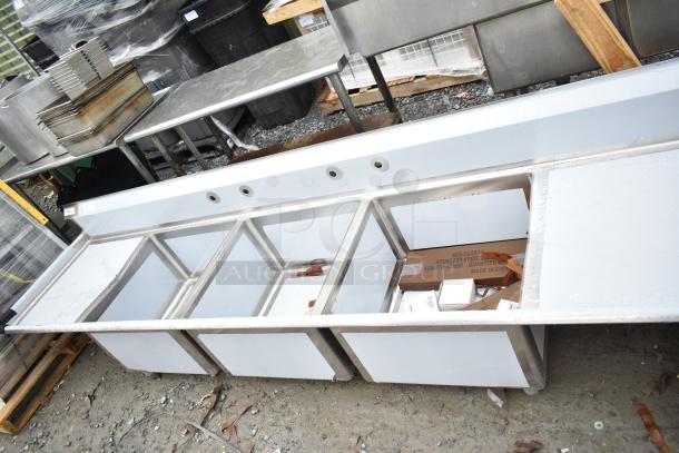 Brand new Regency 600S32424224 commercial 3 bay sink with dual drain boards, visible scratches and dents.