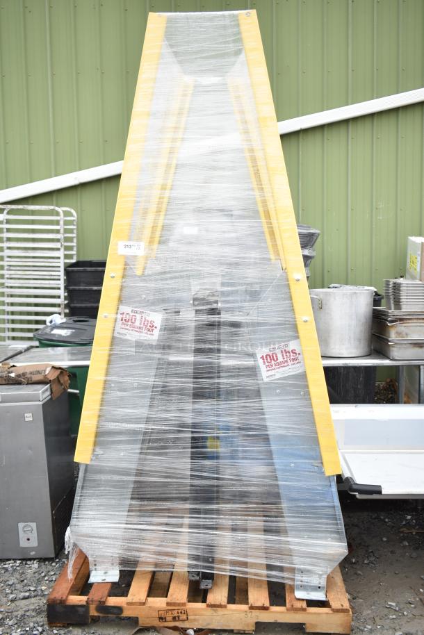 alt="New Equipto ladder wrapped in plastic on pallet, yellow rails, capacity label 100 lbs per sq ft, minor scratches visible."
