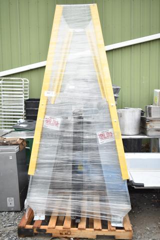 alt="New Equipto ladder wrapped in plastic on pallet, yellow rails, capacity label 100 lbs per sq ft, minor scratches visible."