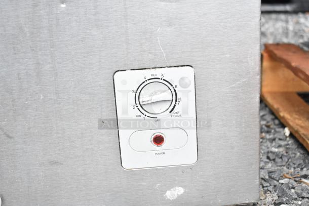 Chest freezer control panel with a temperature dial from Min to Fast Freeze, red power indicator light, and metal finish.