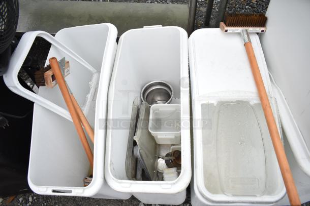 6 white poly ingredient bins with lids, containing cleaning brushes and kitchenware. Used condition.