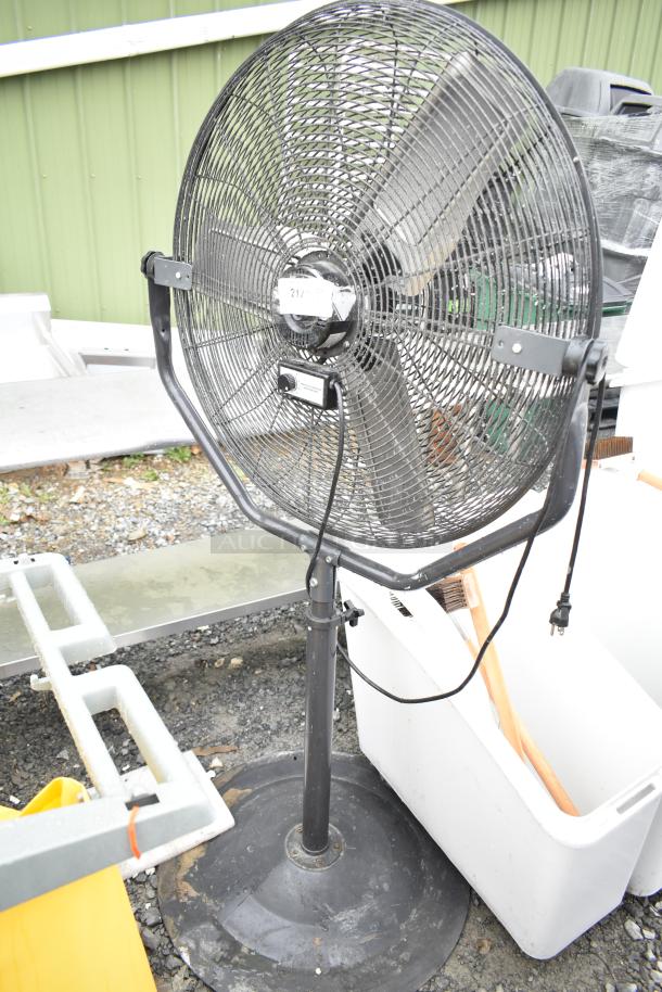 Floor style fan, black metal frame, 115 volts, 1 phase, robust build, used condition, visible power cord and dial.