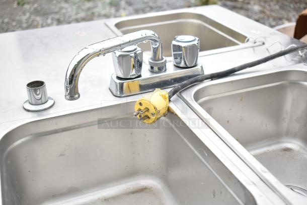 Stainless steel portable sink with dual basins and chrome faucet. Features electric plug for functionality. Slightly used condition.
