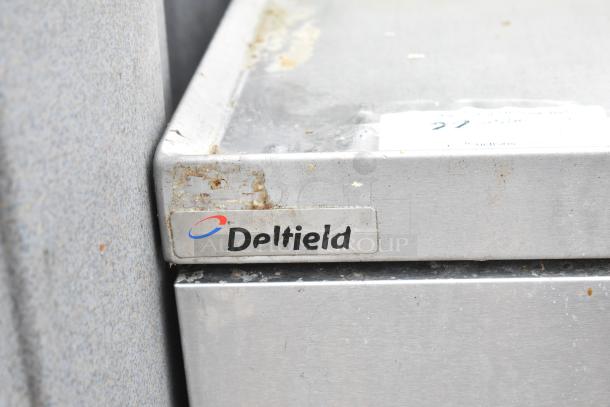 Delfield 2 Drawer Chef Base with visible wear. Features commercial casters, 115 volts, 1 phase. Delfield branding shown.