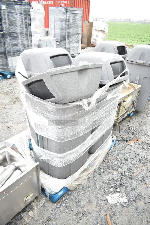 3 gray poly trash cans on a pallet, wrapped in plastic. Used condition. Auction offers three times your bid.
