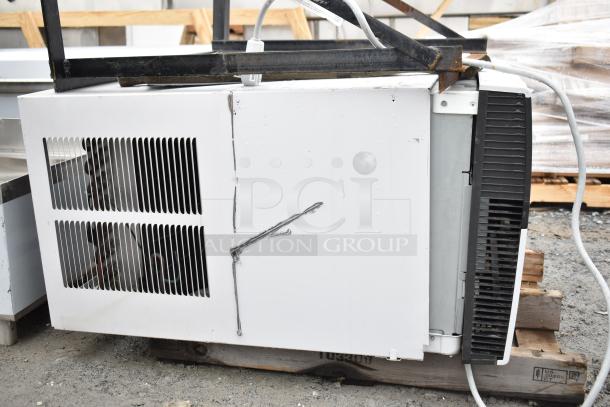 Friedrich air conditioner in used condition, 120/208 volts, 1 phase, visible wear on exterior, mounted on wooden pallet.