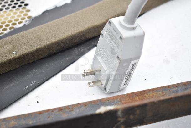 Close-up of a Friedrich air conditioner plug, 120/208 volts, 1 phase, with visible markings, metal edges, and cord detail.