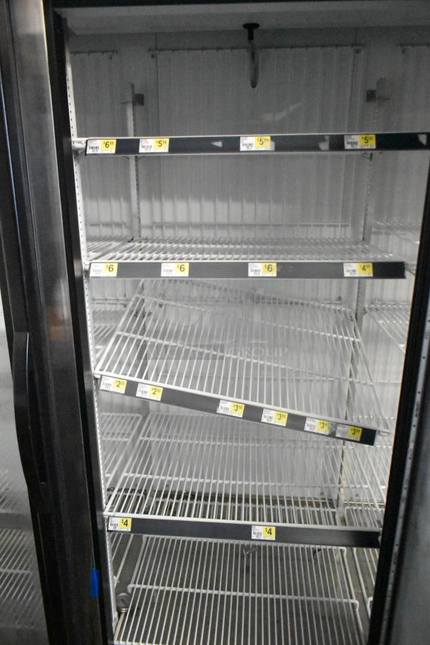 2018 True GDM-72F-HC commercial 3-door freezer, reach-in style, shelving visible, price labels attached.