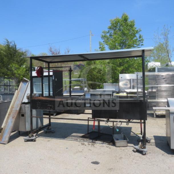 Unique outdoor cooking appliance with grill and dual deep fryer, covered roof, on casters. Measures 109x34x83.