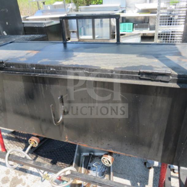 Unique BBQ/frying outdoor cooking appliance with grill, dual deep fryer, and covered roof; measures 109x34x83, on casters.