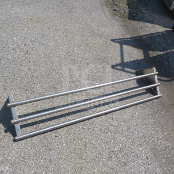 Stainless steel wall mount pot rack, 48x8x7 inches, three-bar design, used, outdoor setting.