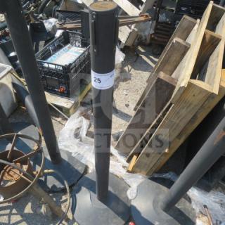 Crowd control pole, black, model 5XBID, sturdy base, visible label with number 25, signs of outdoor use.