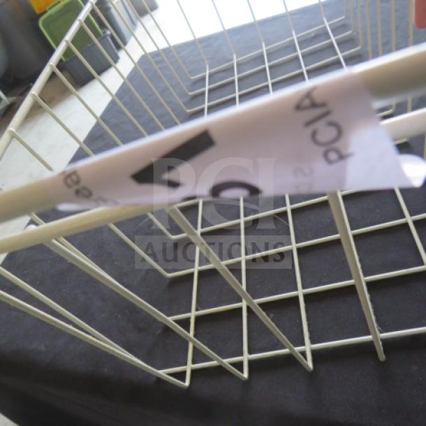 White wire basket, 11x23x10 inches. Features a visible tag with partial black text. Rectangular, lightweight, good condition.