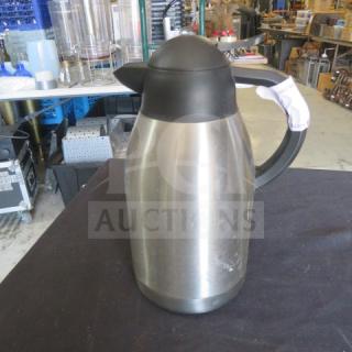 Stainless steel creamer/coffee pot with black handle and lid, good condition, visible tag on handle.