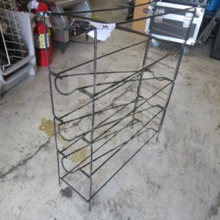Wire cup organizer with multiple tiers in used condition, suitable for kitchen or office storage.