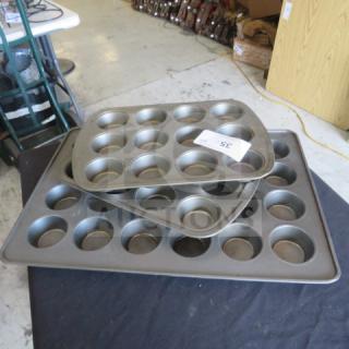 Assorted muffin tin set, three pieces, metal, standard size, used condition, auction label "35" visible.