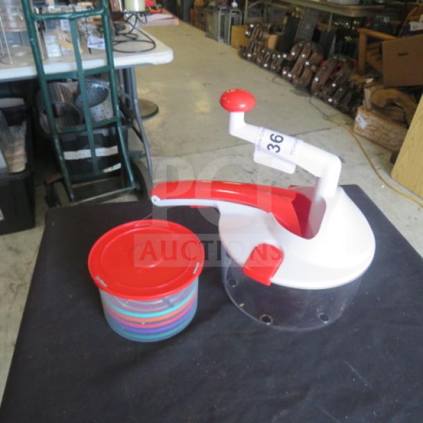 Manual chopper/slicer with red and white handles and clear base, includes matching red-lid container. Item tagged number 36.