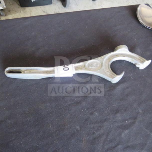 Metal bucket opener with ergonomic handle, embossed "Hales," in good condition, resting on a black surface.