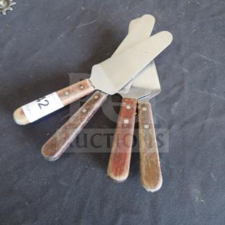 Set of three pizza/pie servers with wooden handles and stainless steel blades. Displayed in used condition.