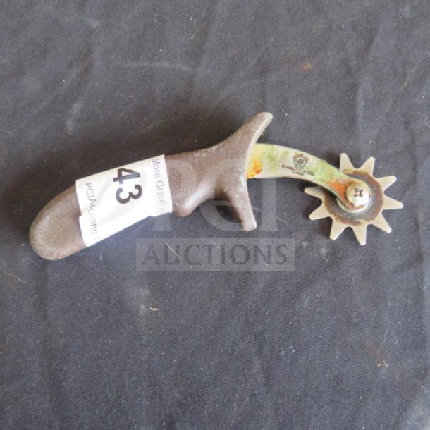 Vintage pastry cutter with a wooden handle and metal rotary wheel. Moderate wear. Auction tag reads "43".