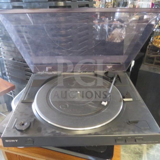 Sony turntable with clear dust cover, black finish, and tonearm. Used, showing some wear. Brand logo visible.