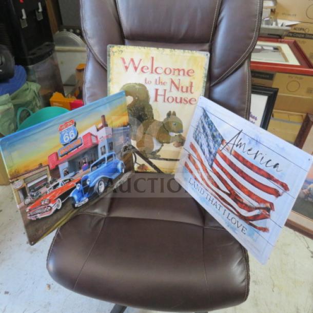 Assorted tin signs featuring Route 66, a squirrel with "Welcome to the Nut House," and an American flag with "America, Land That I Love."
