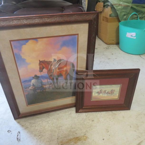 Framed western-themed prints in dark wood frames, one large with a cowboy and horse, one smaller with riders, good condition.
