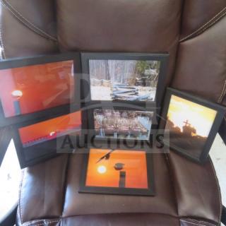 Assorted framed pictures featuring nature and sunset scenes, set of six. Black frames, displayed on a brown chair.