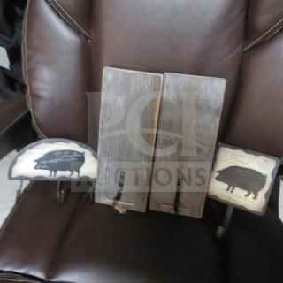 Assorted decor with vintage pig designs on hooks, featuring two rustic wooden panels and two decorative plaques. Good condition.