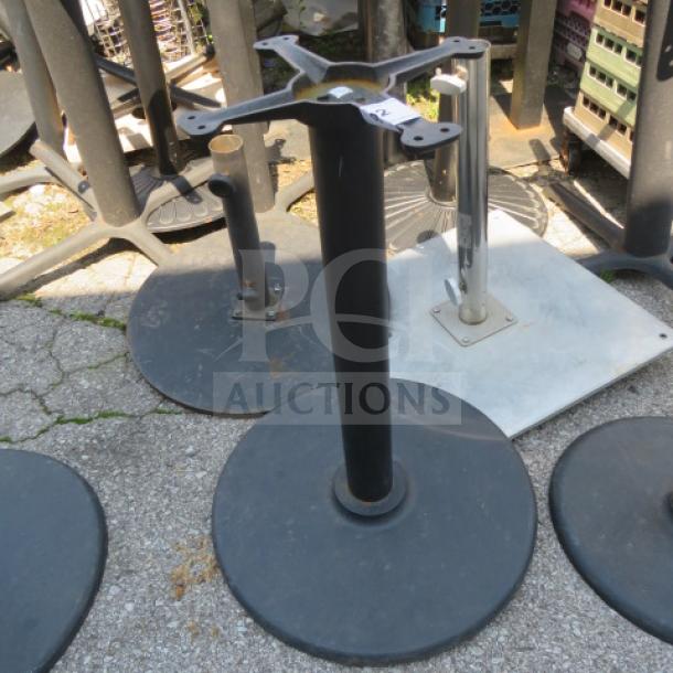 Black metal table base with round, heavy-duty support. Used condition with visible wear. Ideal for replacement or DIY projects.