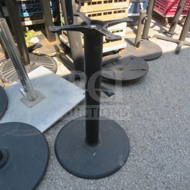 Round black metal table base with mounting bracket, used condition, suitable for various tabletop styles.