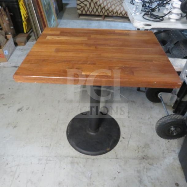 A solid wooden butcher block table top on a pedestal base, 30x24x30, in good condition.