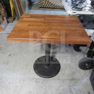 A solid wooden butcher block table top on a pedestal base, 30x24x30, in good condition.