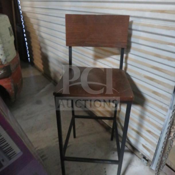 Black metal bar-height chair with wooden seat and back, in good condition, sturdy design.