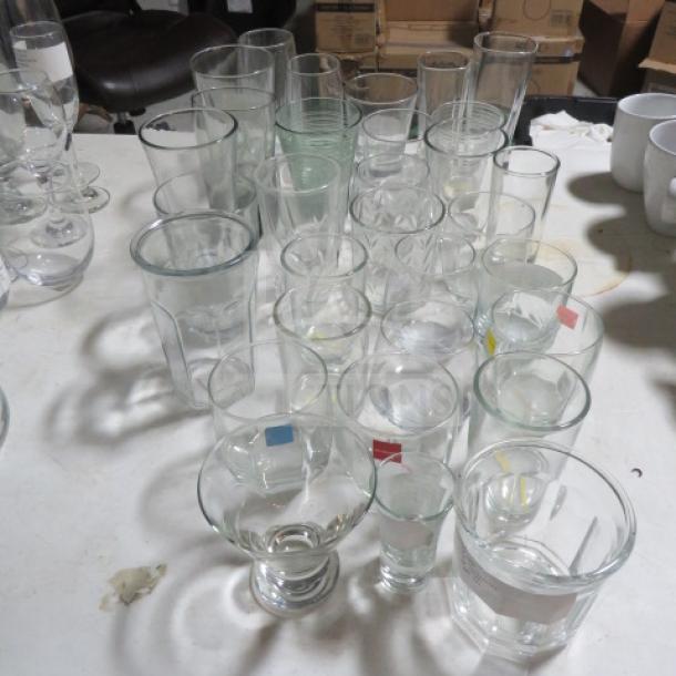Assorted glassware lot including various sizes and shapes, clear glass, mixed condition; ideal for collectors or resellers.