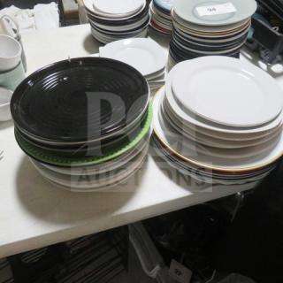 Assorted bowls in various sizes and colors stacked on a table. Good condition, mixed ceramic and porcelain materials.