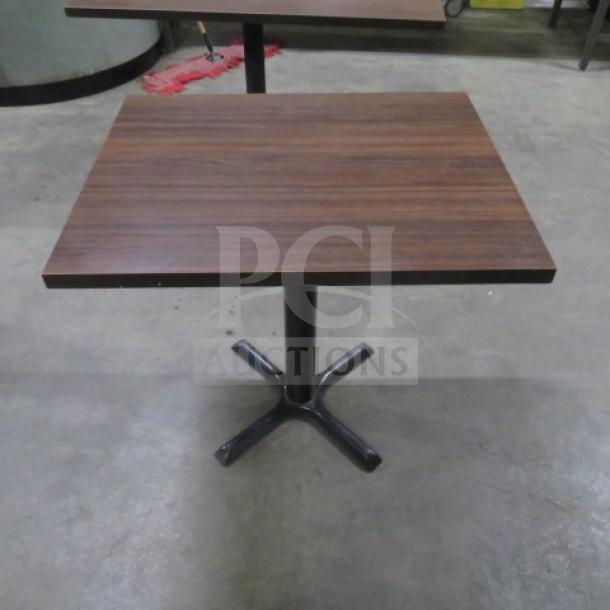Brown laminate tabletop on a black pedestal base, 24x30x30 inches, in good condition.