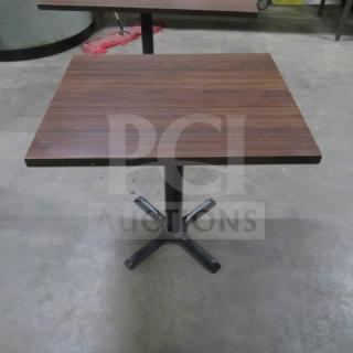 Brown laminate table top on a black pedestal base, 24x30x30 inches, in good condition. Ideal for dining or workspace.