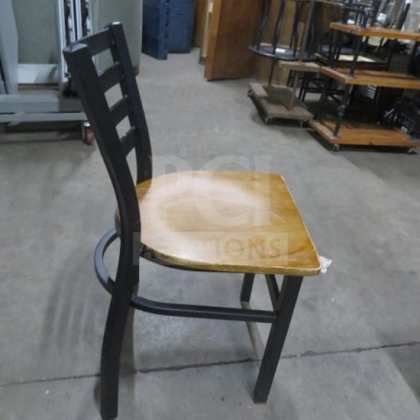 Black metal chair with a wooden seat, model 2XBID. Features a sturdy frame, ladder back, and natural wood finish. Excellent condition.