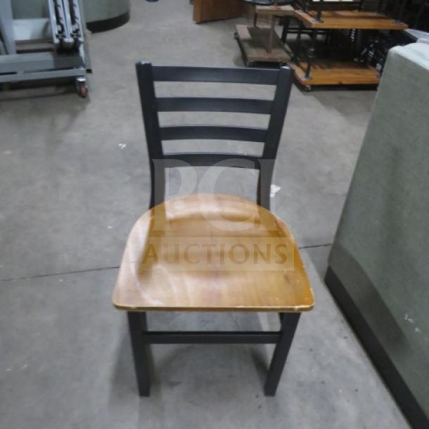 Black metal chair with a wooden seat. Features ladder-back design. Condition: Used. 2XBID model.