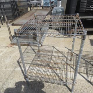 Metro metal shelf unit, 24x24x32 inches, with two wire shelves. Used condition, visible rust; sturdy for storage use.