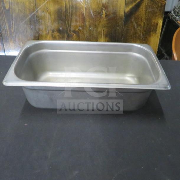 Stainless steel 1/3 size, 4-inch deep hotel pan, used condition. Smooth surface with visible light wear. Suitable for food service.