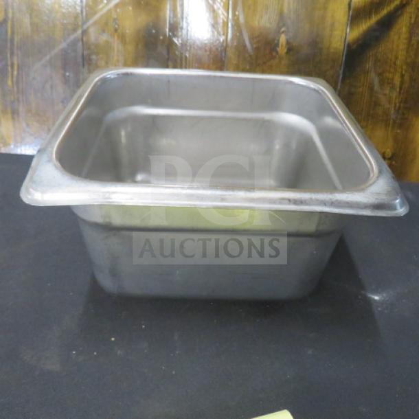 1/6 size, 4-inch deep stainless steel hotel pan. Shows signs of use; minor surface scratches. Model: 2XBID.